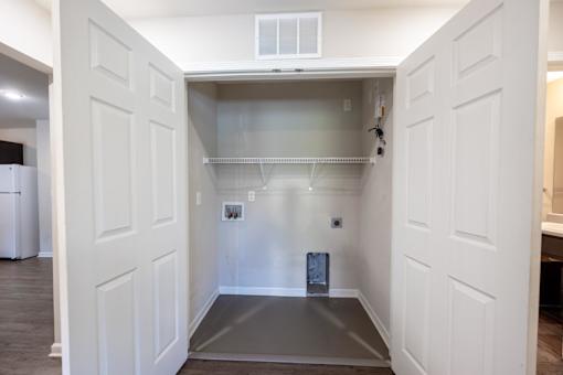 A white doorway leads to a small, empty room with a grey floor.