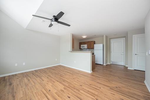 A room with a ceiling fan and wooden flooring.