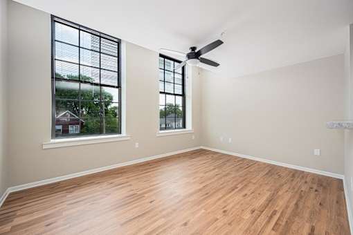 A room with wooden floors and a ceiling fan.