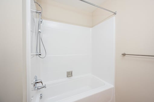A white bathtub with a shower head and a faucet.