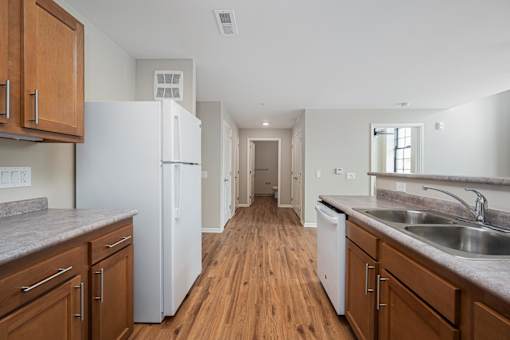 A kitchen with wooden cabinets and a white refrigerator.