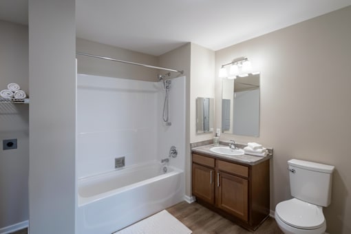 A white bathroom with a toilet, sink, and bathtub.