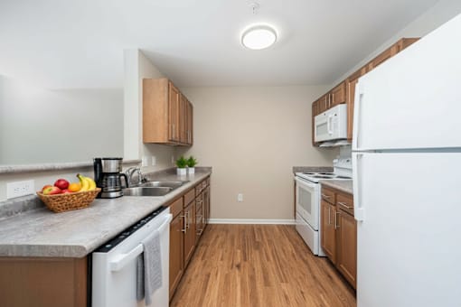 A kitchen with a white dishwasher and white refrigerator.