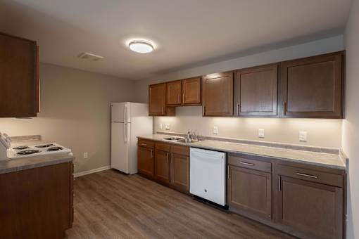 A kitchen with brown cabinets and a white refrigerator.