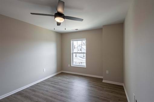 A room with a ceiling fan and a window.