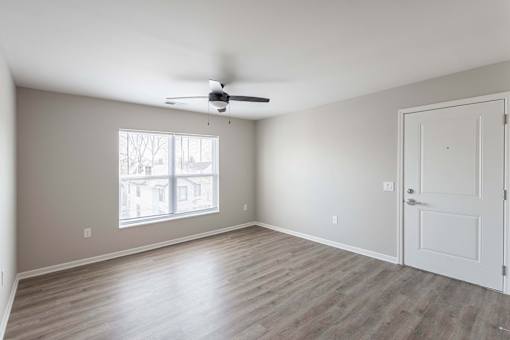 A room with a ceiling fan and a door.