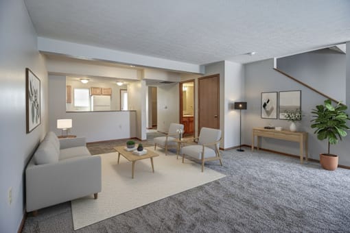 A living room with a grey couch, a wooden coffee table, and a potted plant.
