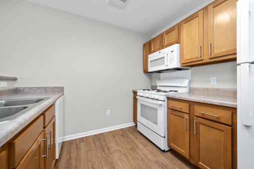 a kitchen with wood cabinets and white appliances