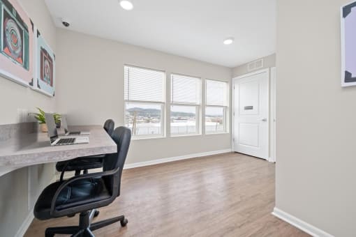 a home office with hardwood floors and a large window