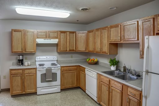 A kitchen with wooden cabinets and a white stove top oven.