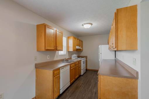 A kitchen with wooden cabinets and appliances.