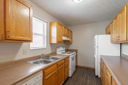 A kitchen with wooden cabinets and white appliances.