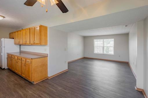 A kitchen with wooden cabinets and a refrigerator.