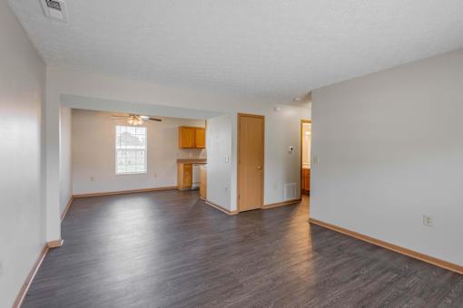 A large empty room with wooden floors and white walls.