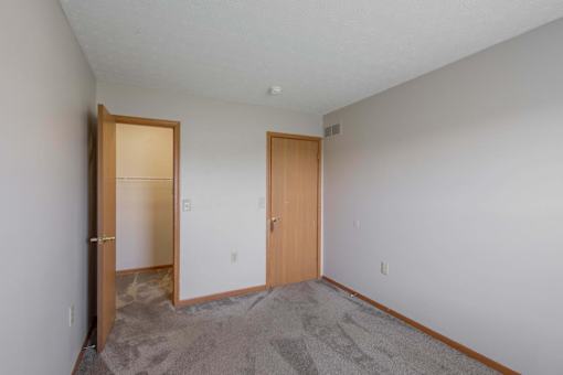 A room with two doors and carpeted floor.