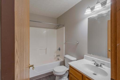 A bathroom with a white toilet, a white sink, and a white bathtub.
