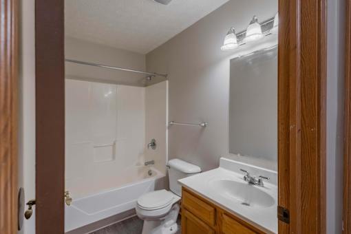 A bathroom with a toilet, sink, and bathtub.