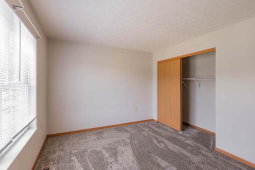 A room with a carpeted floor and a wooden door.
