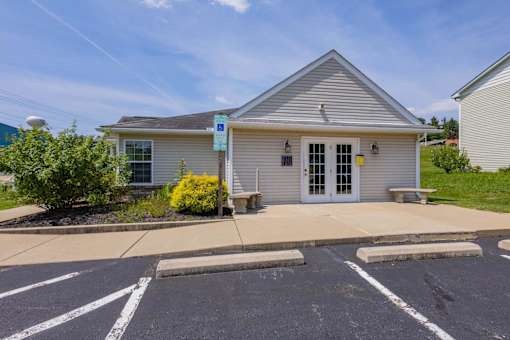 A small building with a parking lot in front.