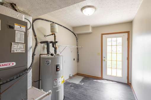 A room with a window and a door, and a furnace and air conditioner.