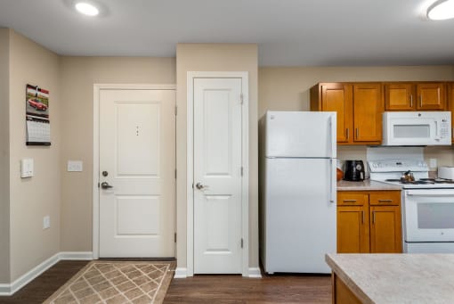 a kitchen with a white refrigerator freezer next to a stove top oven