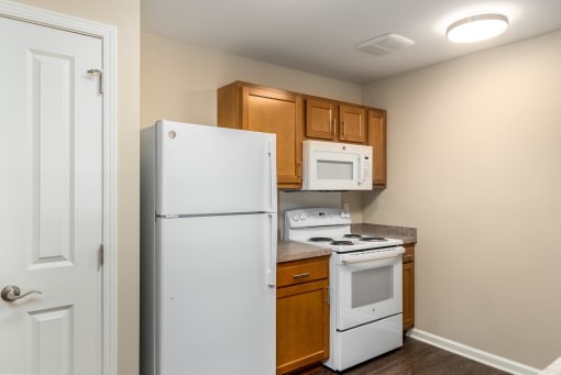 our apartments have a small kitchen with a white stove and refrigerator