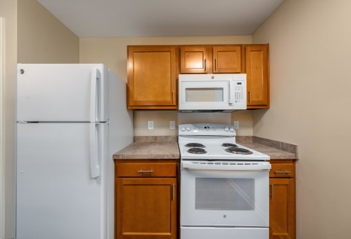 a kitchen with white appliances and brown cabinets