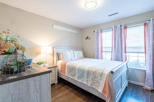 A bedroom with a bed, nightstand, and window.