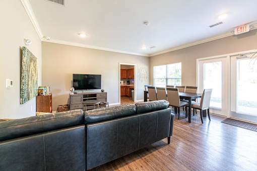 A living room with a black couch and a television.