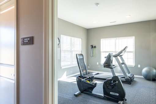 A gym with a treadmill and exercise bike.