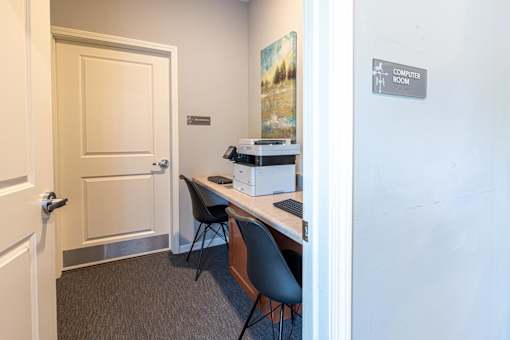 A room with a desk and a computer in it.