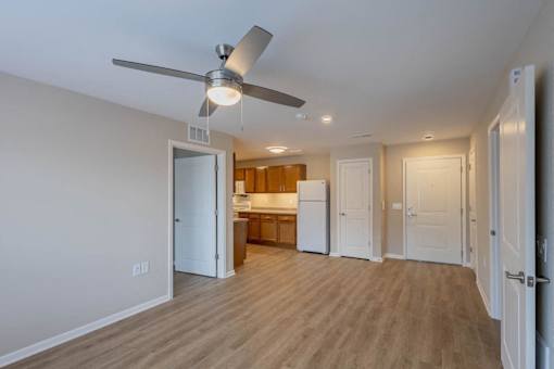 A room with a ceiling fan and wooden flooring.