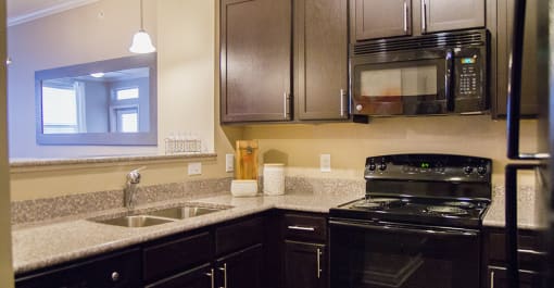 a kitchen with black appliances and granite counter tops