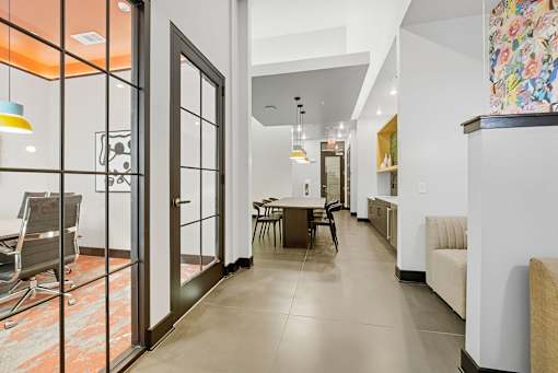 A modern living room with a glass door and a dining table.