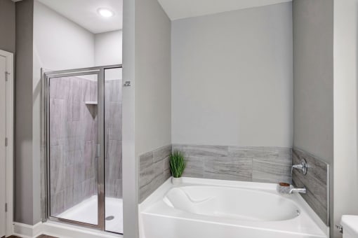 a white bathroom with a tub and a shower