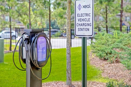 a purple electric vehicle charging station with a sign in the background