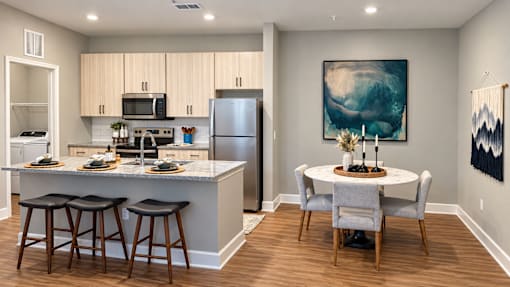 A kitchen with a bar and a dining table.
