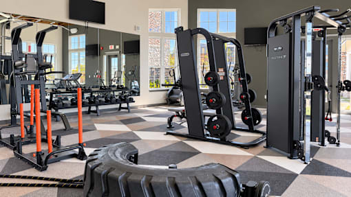 A gym with a variety of equipment including treadmills, weights, and exercise machines.