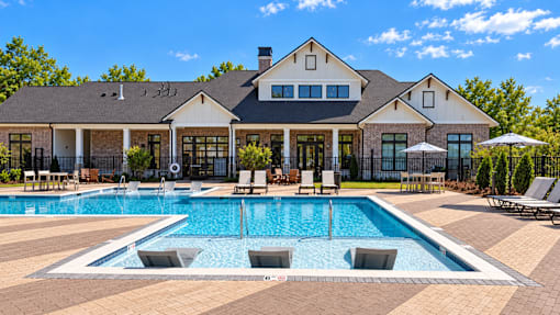 A large house with a pool in front.