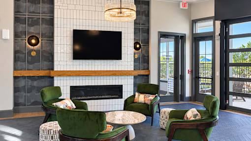 A living room with a fireplace and green chairs.