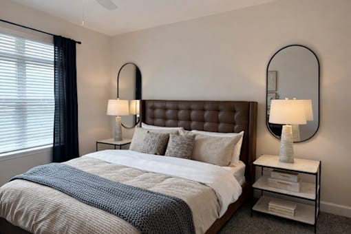 A bedroom with a large bed and two lamps.