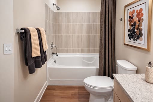 A bathroom with a white tub, toilet, and sink.
