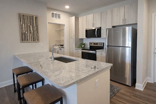 A kitchen with a granite countertop and stainless steel appliances.