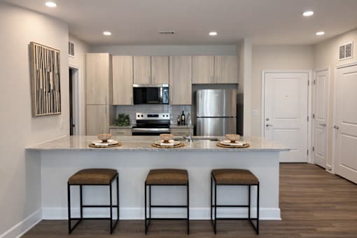 A modern kitchen with a bar area and stools.