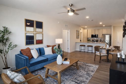 A living room with a blue couch and a wooden coffee table.
