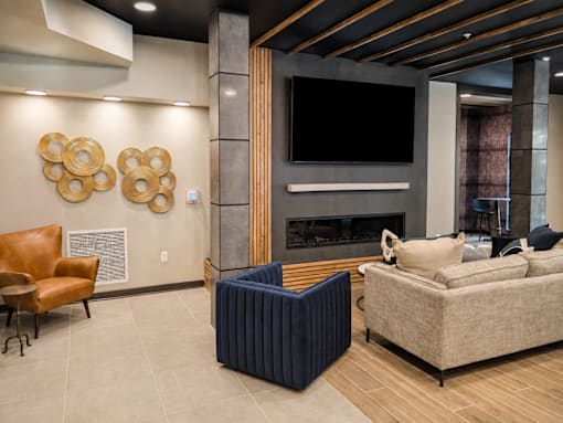 Resident lounge with fireplace, television and modern seating at Argento on the Broad apartments in Arden, NC