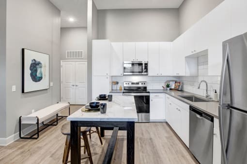 a modern kitchen with stainless steel appliances and white cabinets