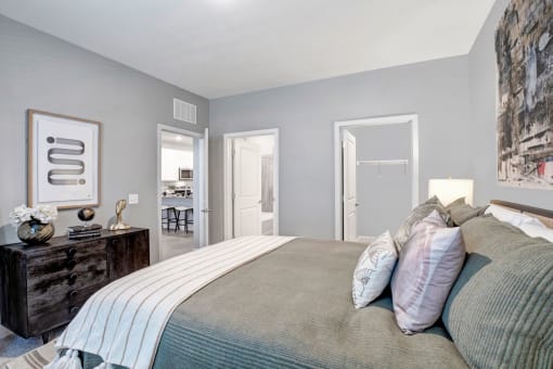 a bedroom with a large bed and a door to a bathroom
