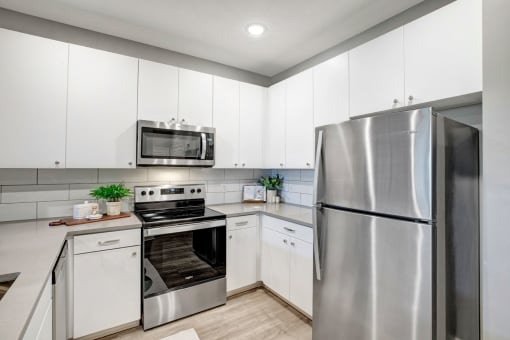a kitchen with stainless steel appliances and white cabinets