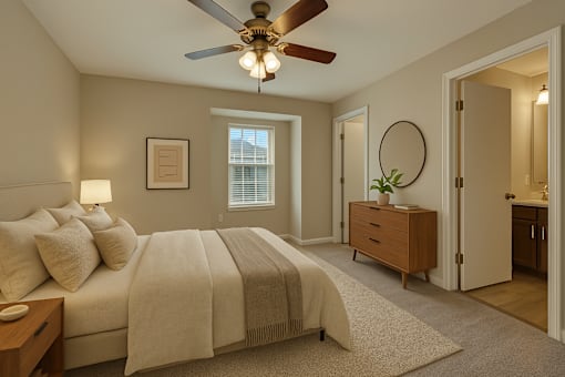 A bedroom with a large bed and a ceiling fan.